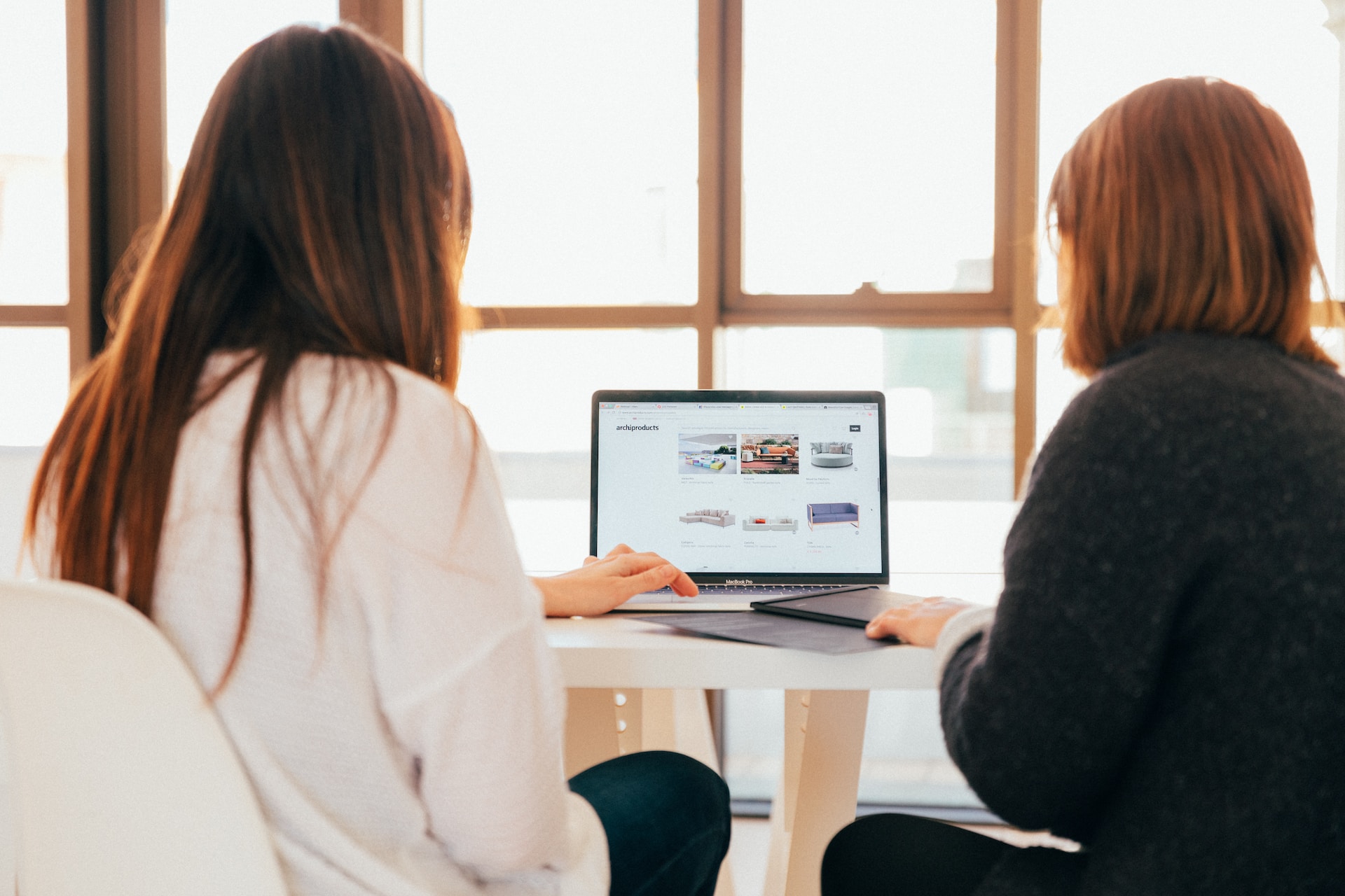 Two women sitting and working on a laptop